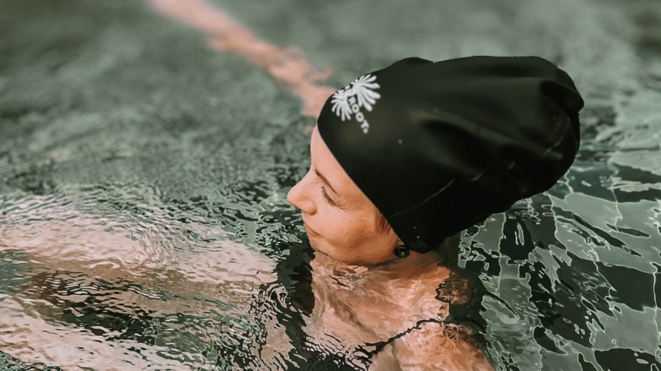 Woman swimming with her hair in a dreadlock swimming cap